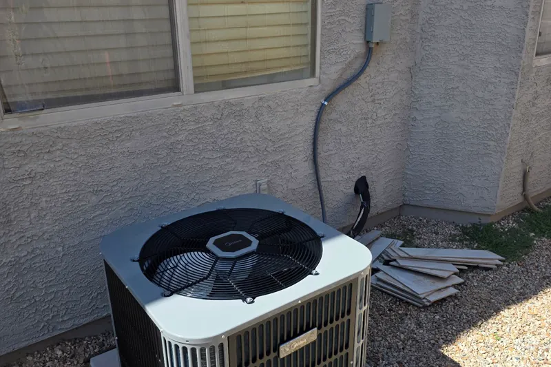 Outdoor AC condenser on a pad beside an East Valley home